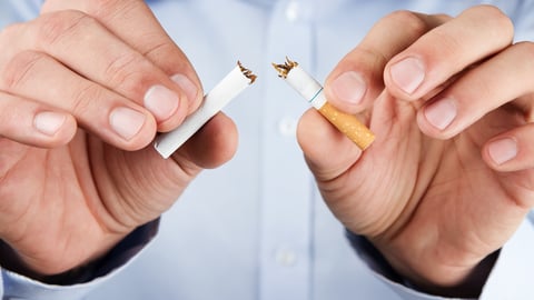 Human hands breaking a cigarette