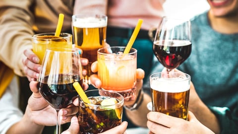 Young people having fun together drinking cocktails, wine and beer at happy hour