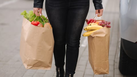 Groceries from a supermarket in a eco craft package. Food delivery concept. Paper eco bags full of fresh food. Woman hold two package. High quality photo; Shutterstock ID 2456125805