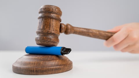 Judge hammering disposable vape with referee's gavel on white table. ; Shutterstock ID 2194172063