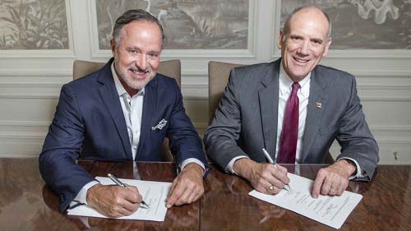 Parker's CEO Greg Parker, left, signs a landmark gift agreement with Georgia Southern University’s College of Business Dean Allen C. Amason.