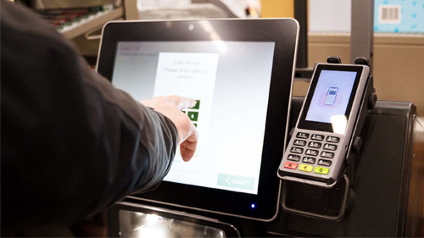 A customer using a self checkout kiosk