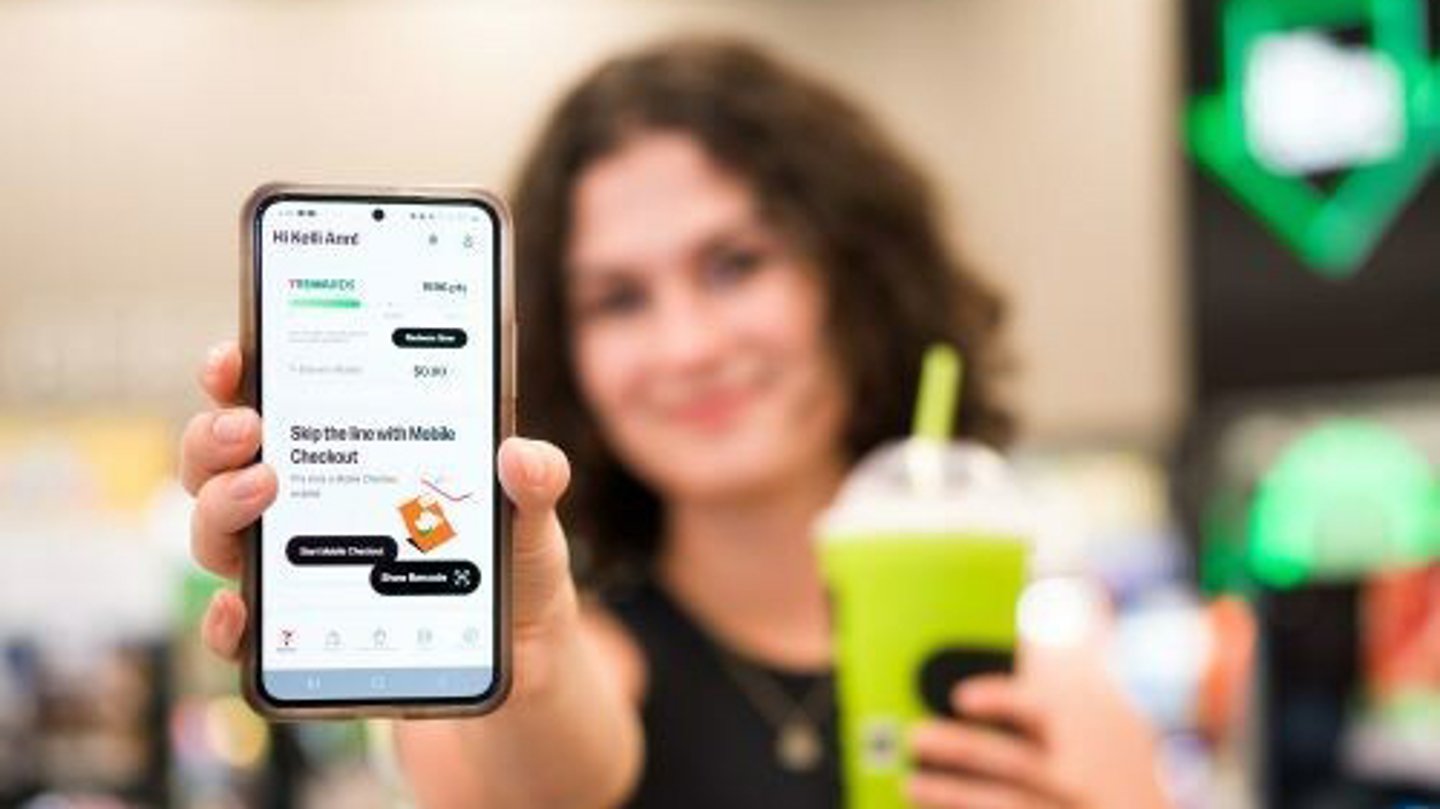 A customer holding 7-Eleven's new app