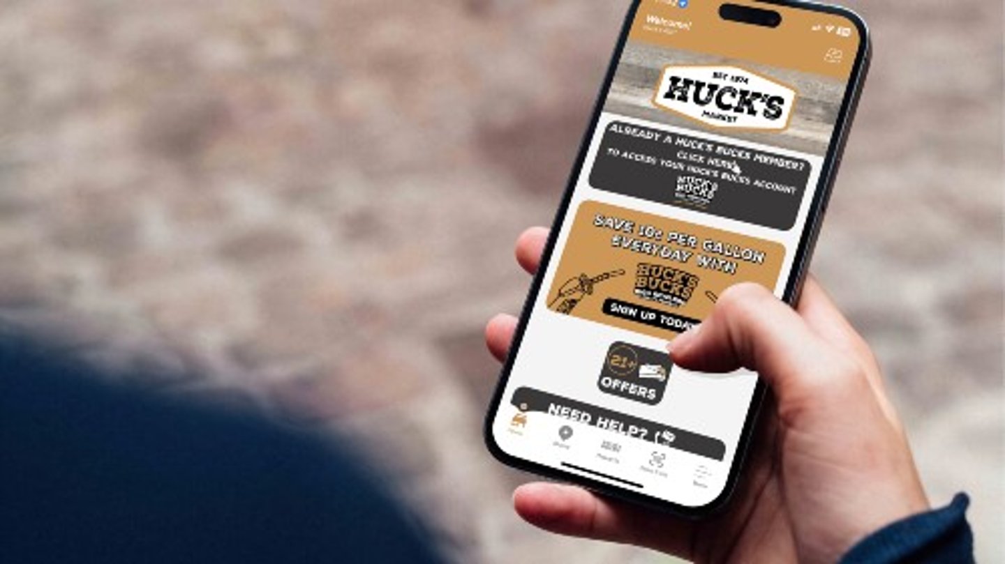 Hand holding phone with Huck's app on it