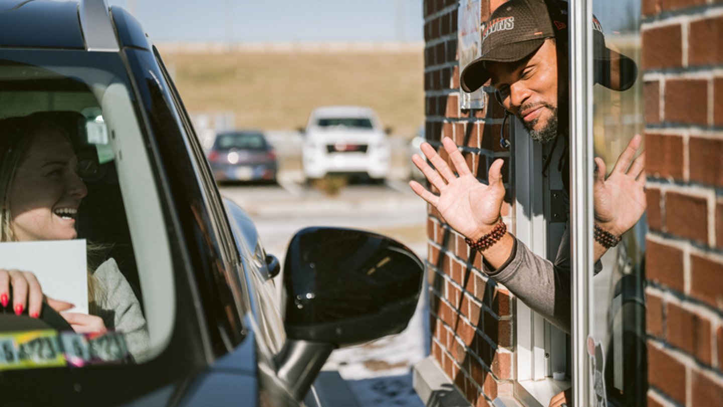 A customer picking up food at the drive-thru window at GetGo