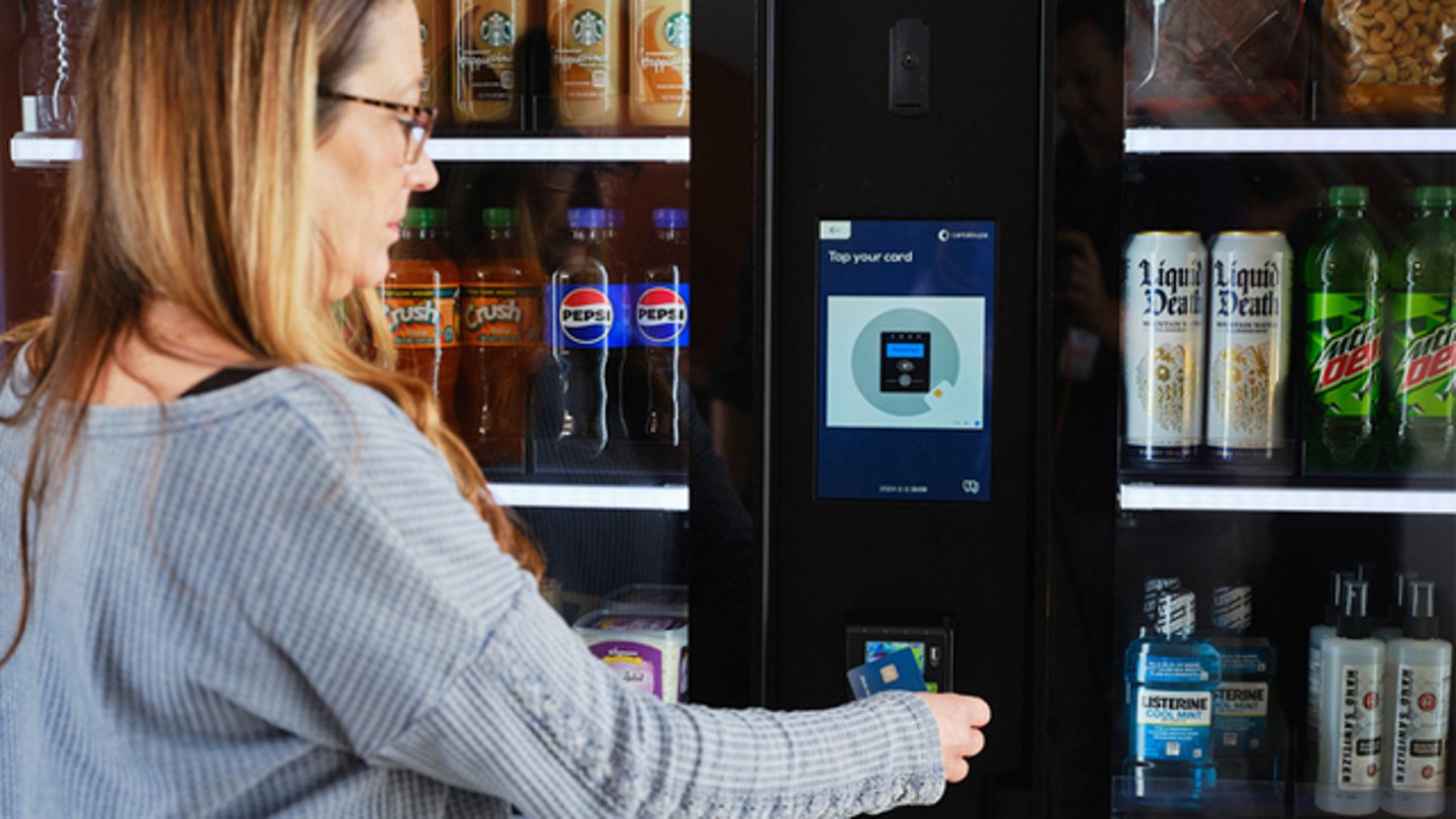 A female shopper swiping her credit at Cantaloupe Smart Series kiosk