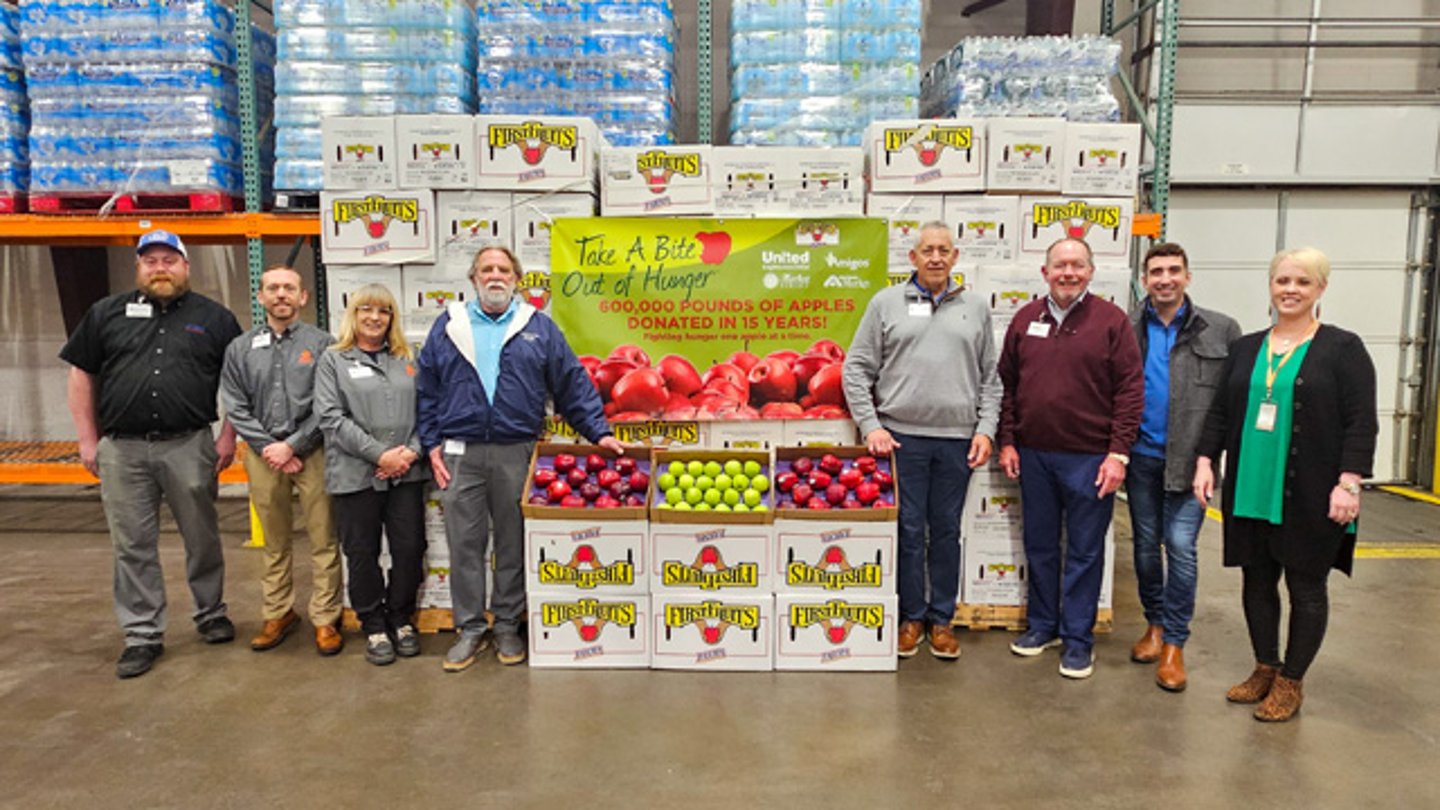Team members from The United Family and a display for the Take a Bite Out of Hunger program