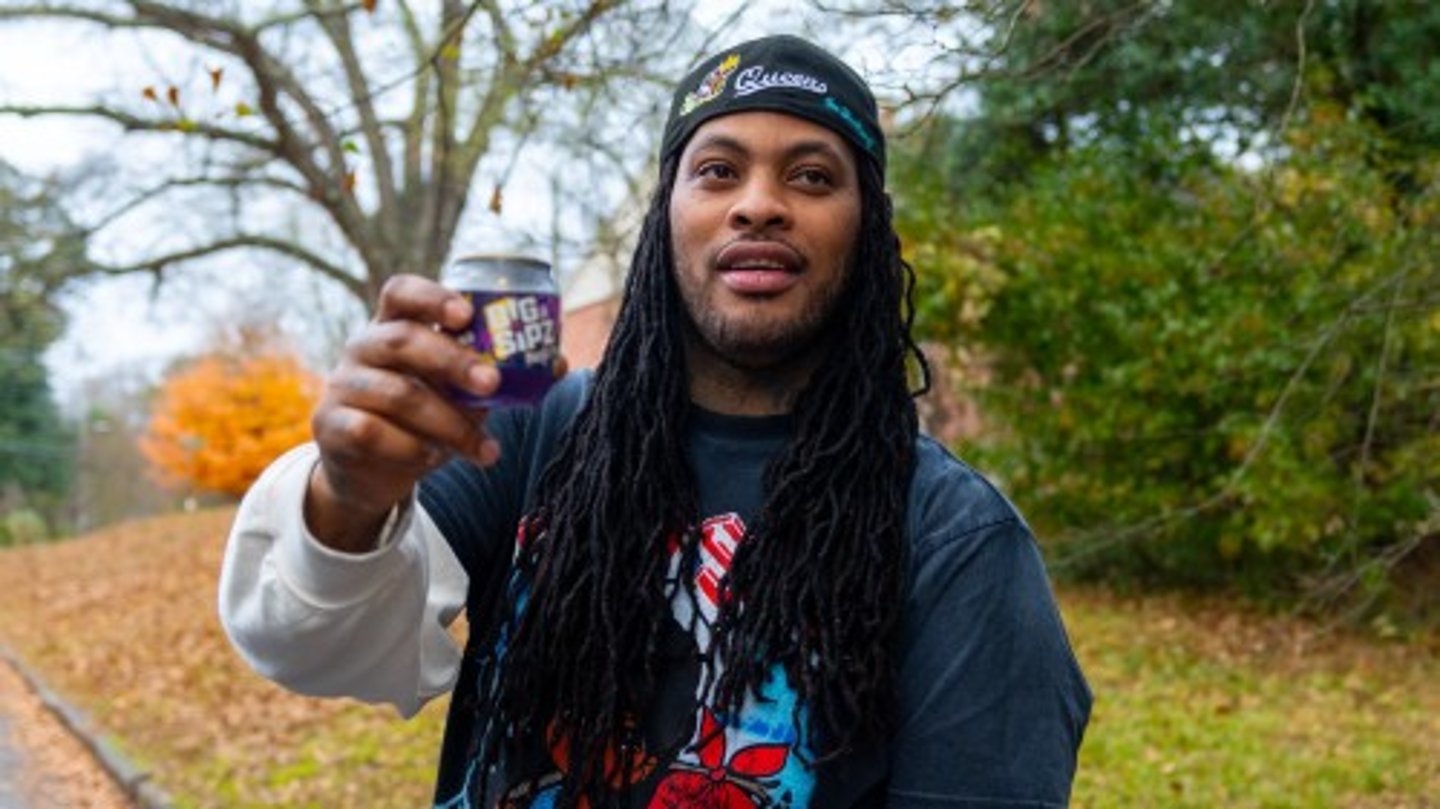 Waka Flocka Flame holding up a Big Sipz Purple Punch can 