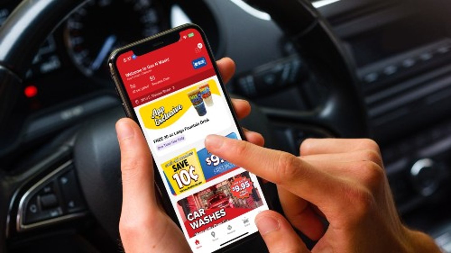 A person using the Gas N Wash app while sitting in the driver's seat of a car