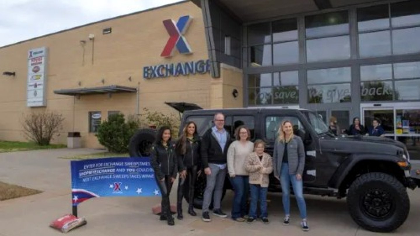 Winners of a Jeep Rubicon stand outside the Army and Air Force Exchange Service