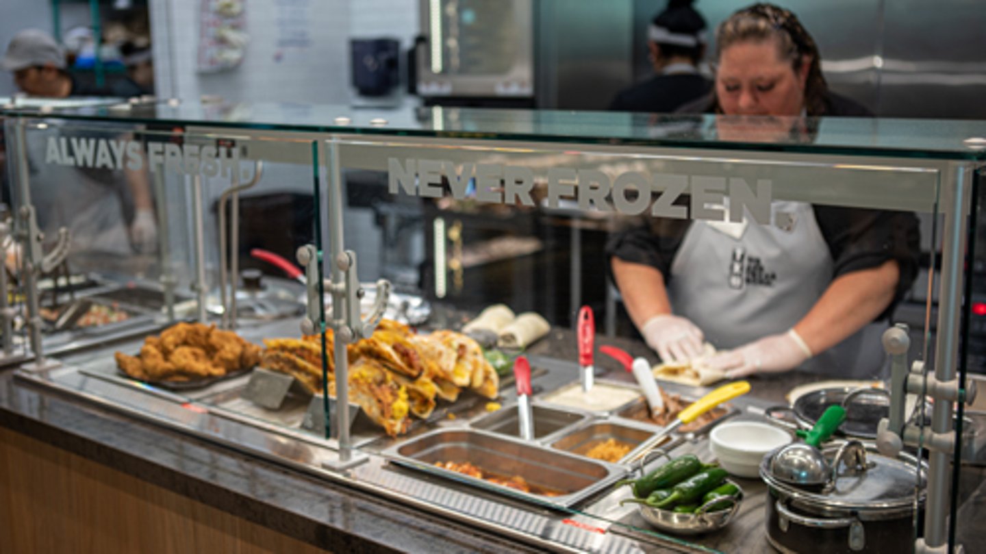 An employee preparing fresh food at a TXB convenience store