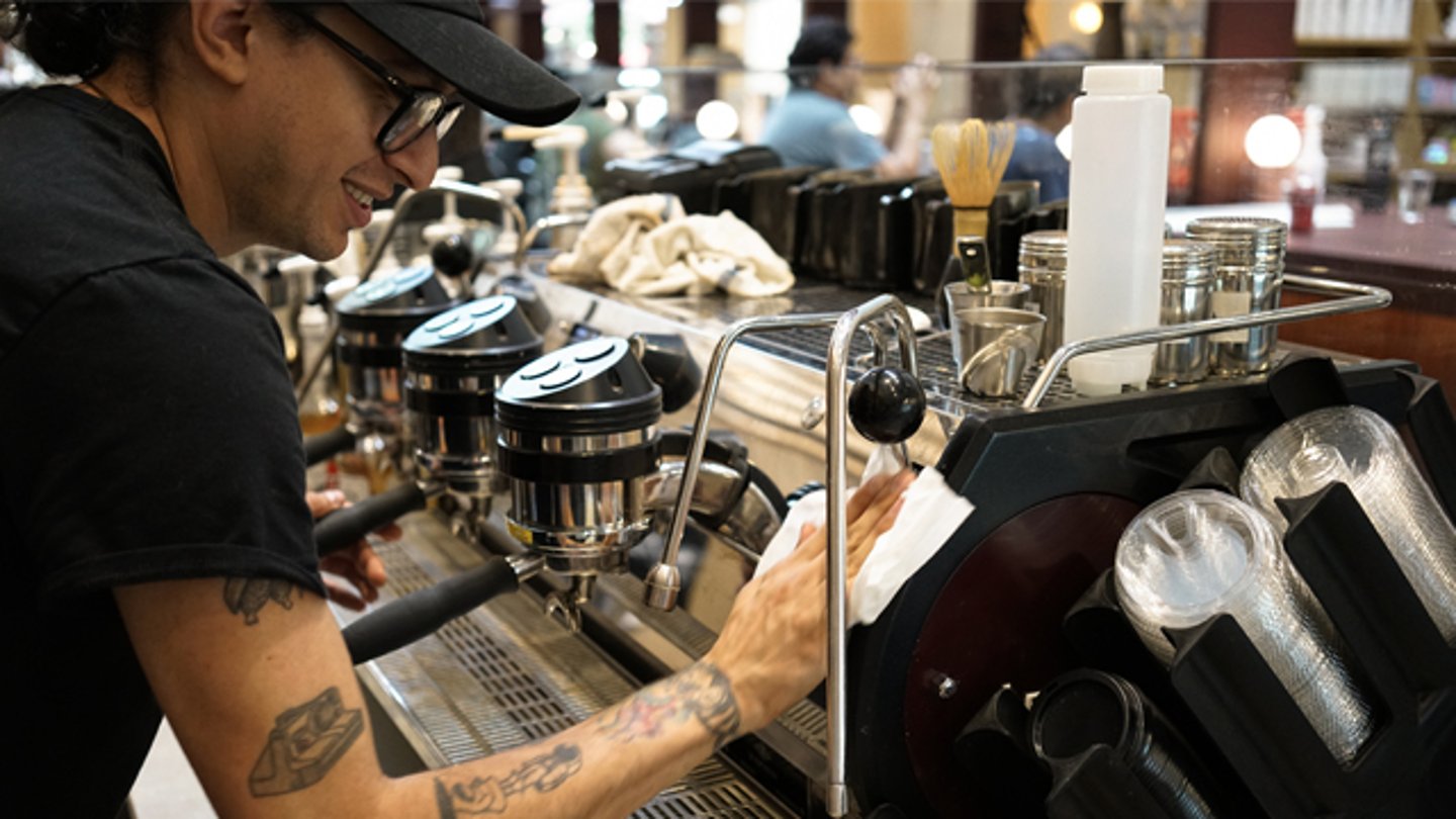 A Foxtrot employee brewing coffee