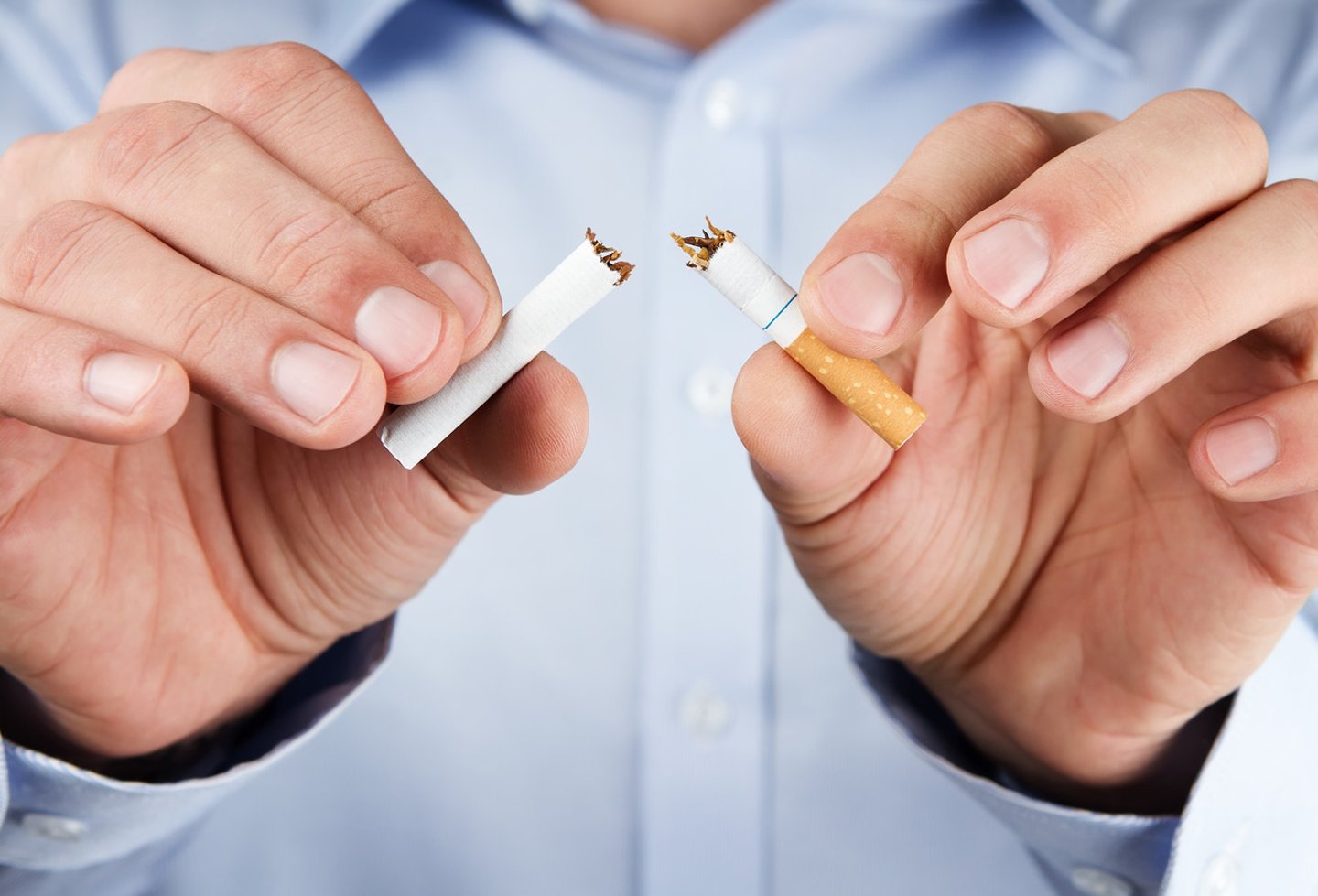 Human hands breaking a cigarette