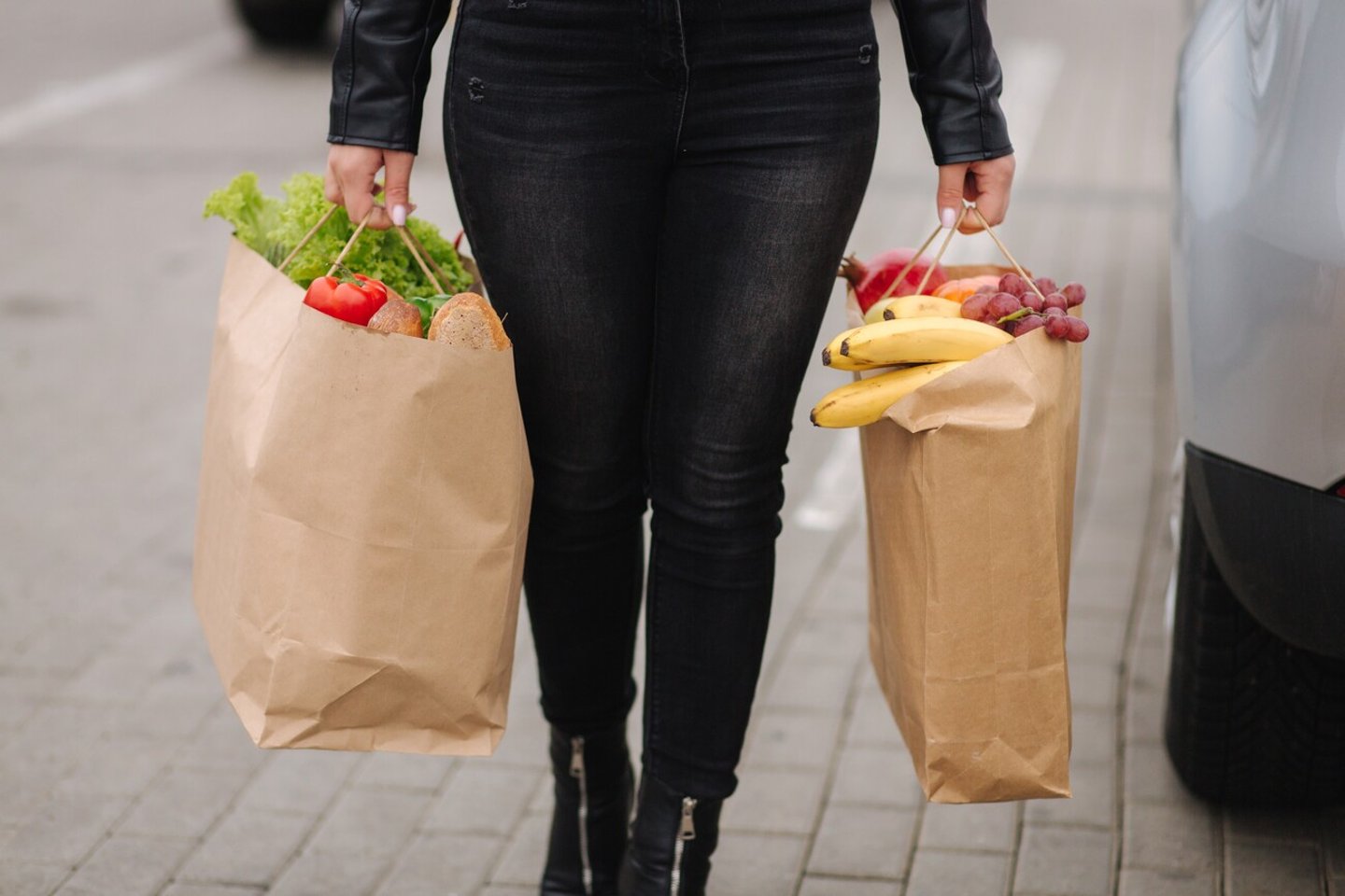 Groceries from a supermarket in a eco craft package. Food delivery concept. Paper eco bags full of fresh food. Woman hold two package. High quality photo; Shutterstock ID 2456125805